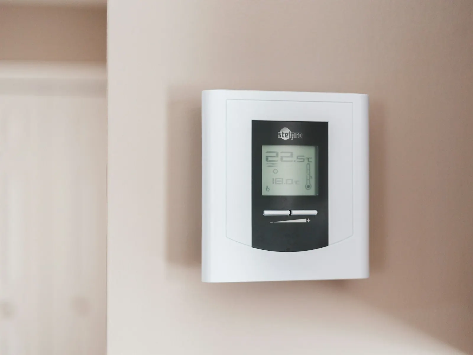 A wall-mounted comfort control shown as a representative property-device direction