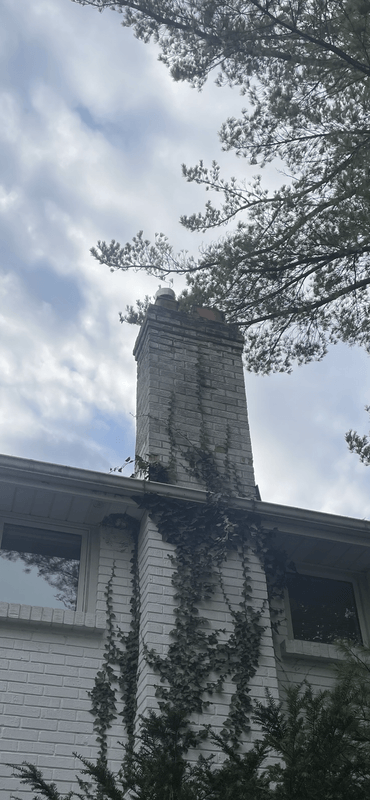 Side view of a house showing original red brick chimney before complete stone replacement in London Ontario