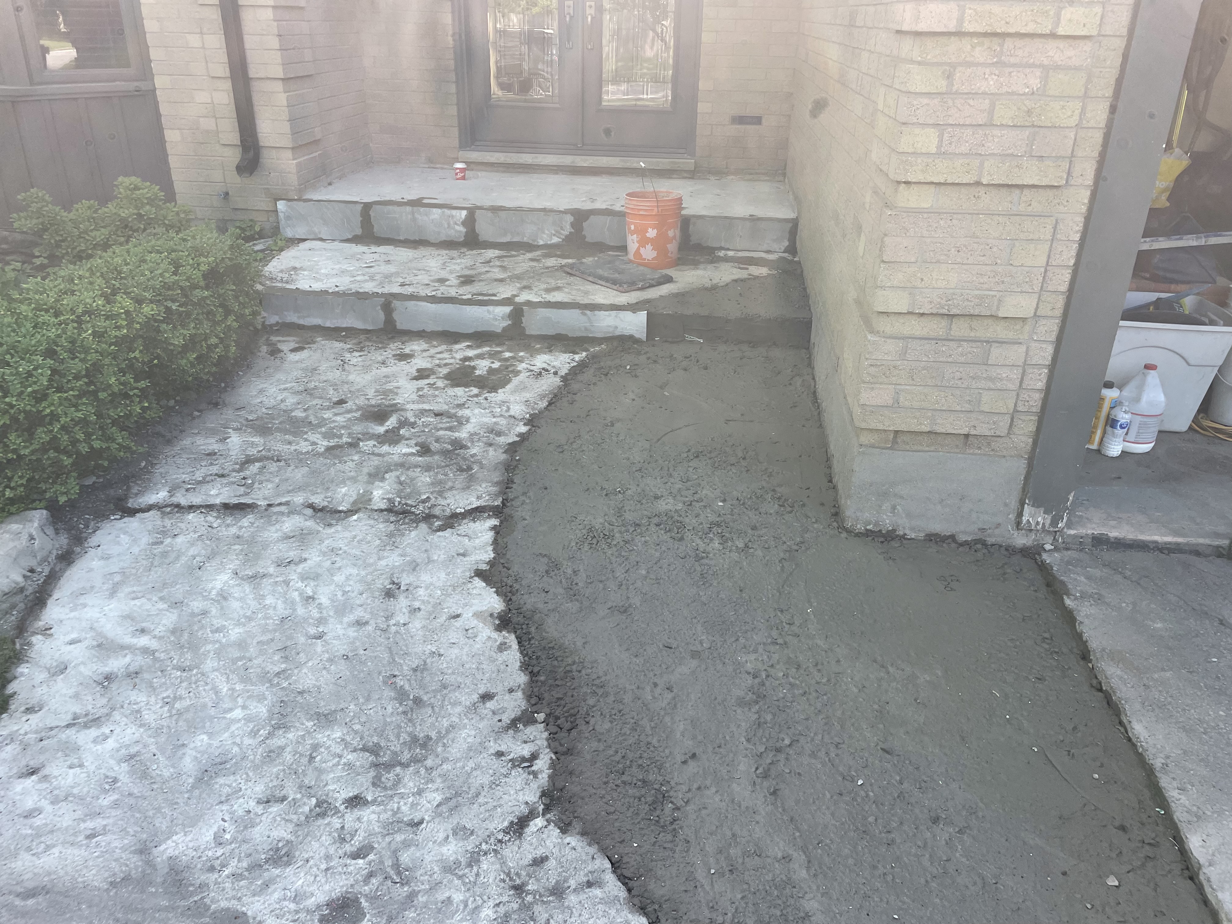 Front entry steps and porch before restoration showing stained and mismatched stonework in London Ontario