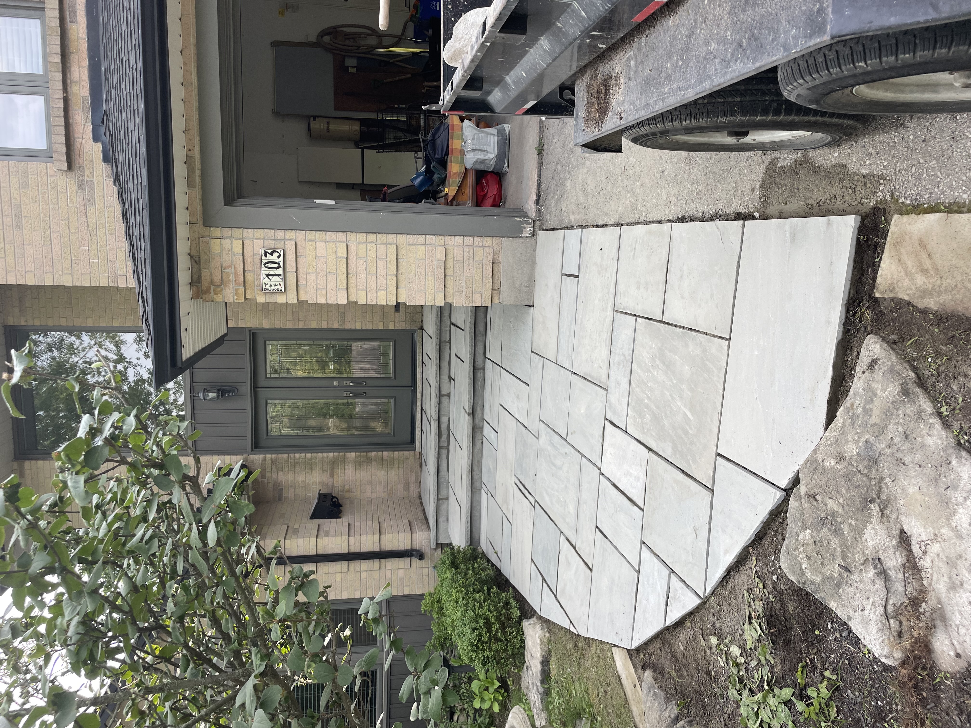 Refinished front steps and porch after restoration with modern large-format natural stone and clean grout lines in London Ontario